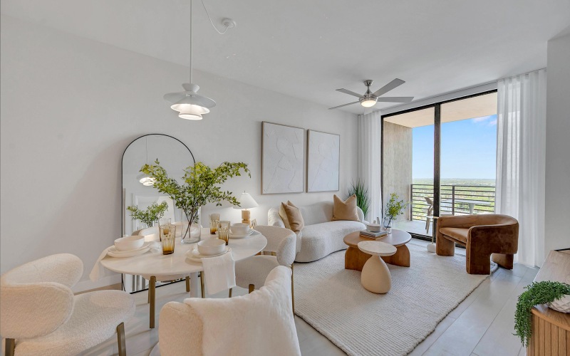 a living room with a large window plant seating and mirror