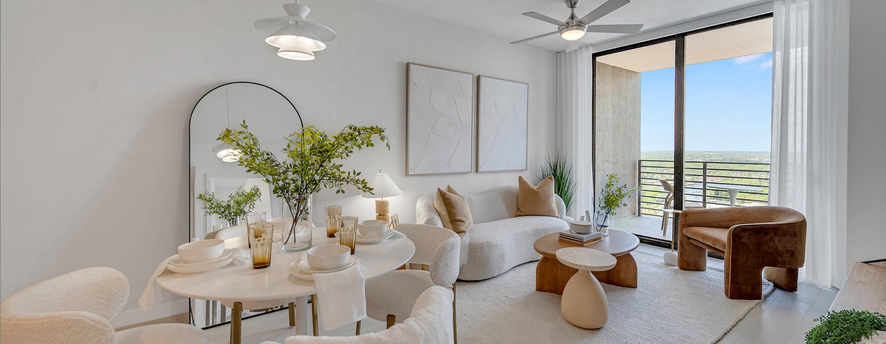 a living room with a large window plant seating and mirror