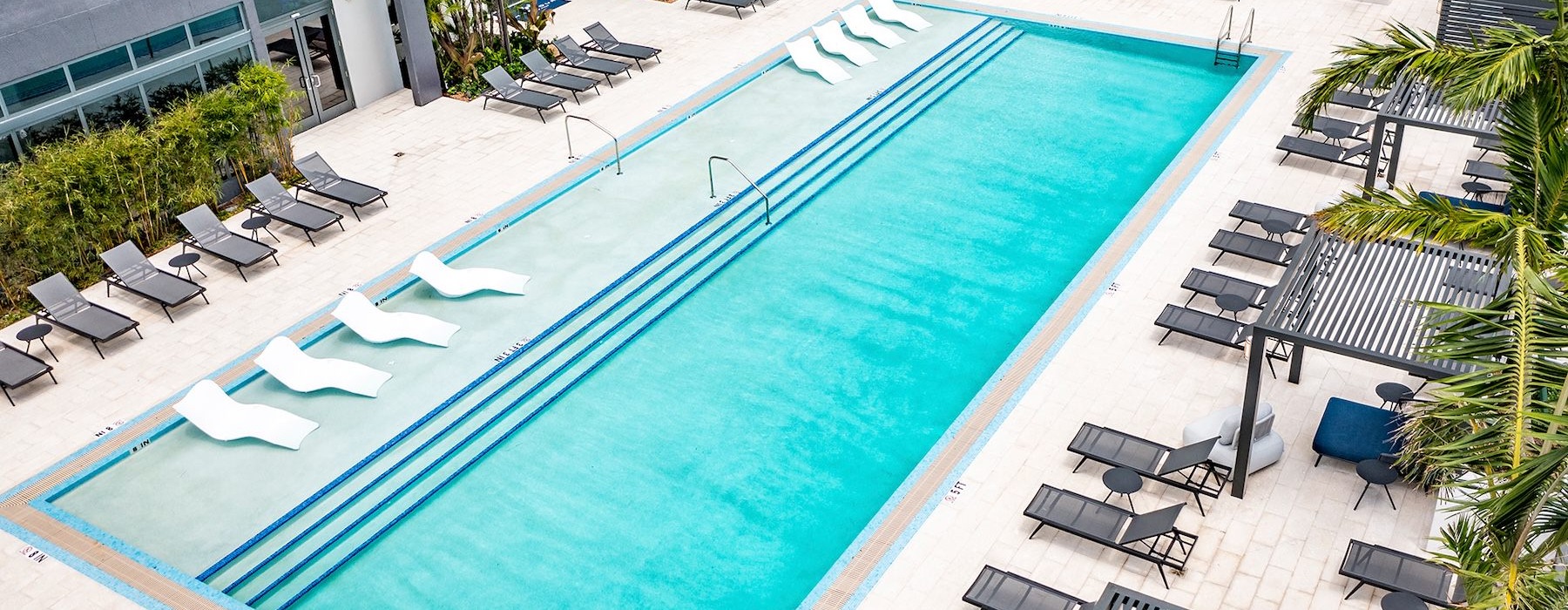 resort style pool with seating and a building behind