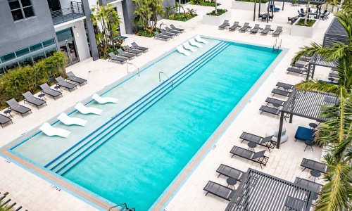 resort style pool with seating and a building behind